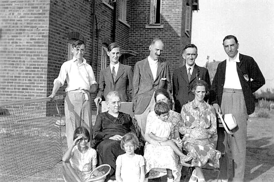 A group at Gower’s house.  He stands in the centre with his brother Leonard at the far right.  His mother and Freda sit with Amy Child/Barton and her three children.  About 1932
