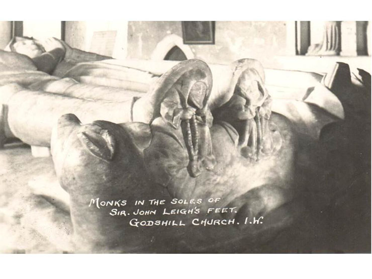 Godshill Church - figures of monks in the soles of Sit John Leigh’s feet on his tomb, in a postcard of perhaps the 1930s 