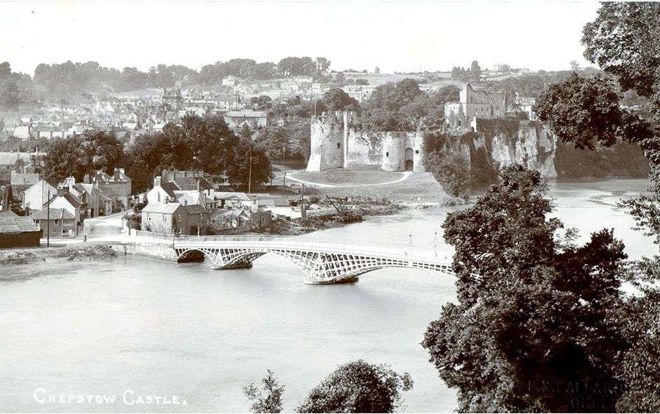 A stunning view of Chepstow with the castle and bridge.  Taken from the cliff on the Gloucestershire side of the Wye, around 1900.The image is stamped by Ballard and produced as a large-format postcard.